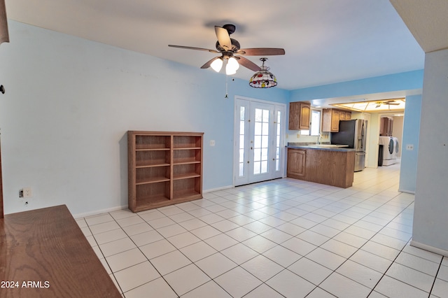 kitchen featuring ceiling fan, stainless steel refrigerator with ice dispenser, kitchen peninsula, washer / dryer, and light tile patterned flooring