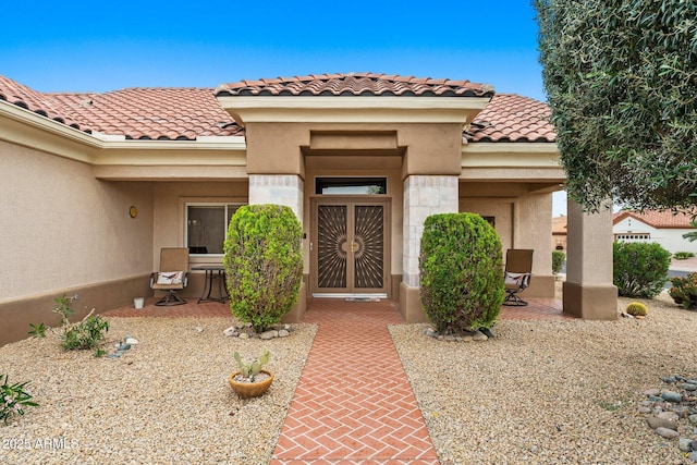 view of exterior entry with a patio area