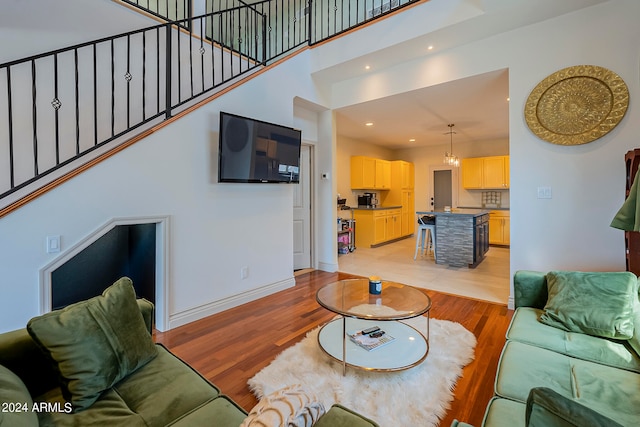 living room featuring light wood-type flooring and a high ceiling