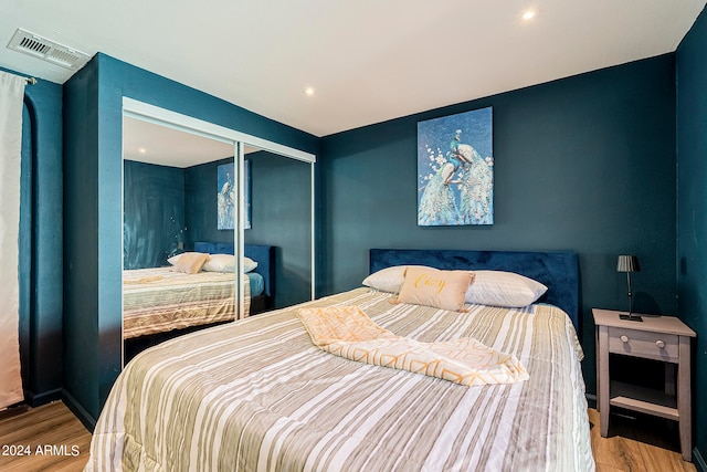 bedroom with hardwood / wood-style floors and a closet