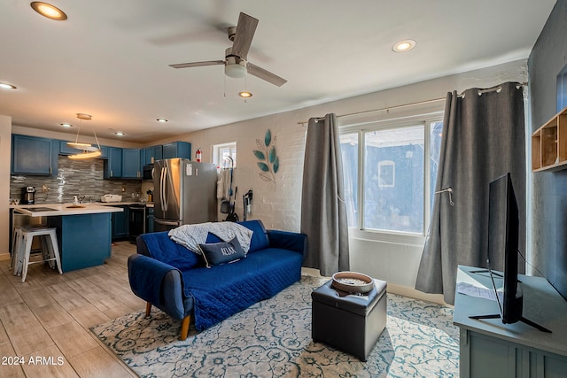 living room featuring light hardwood / wood-style flooring and ceiling fan