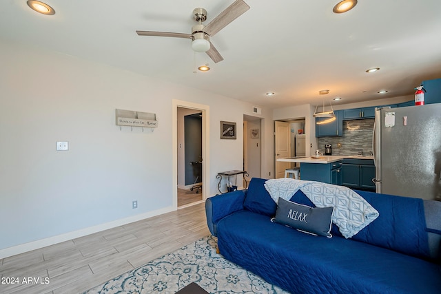 living room with ceiling fan and light wood-type flooring