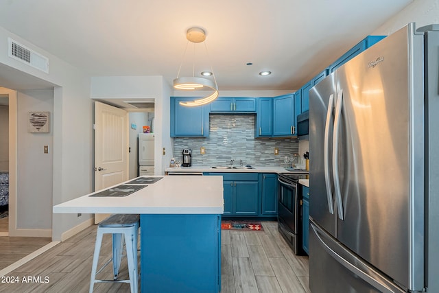 kitchen with hanging light fixtures, blue cabinets, a center island, and stainless steel appliances