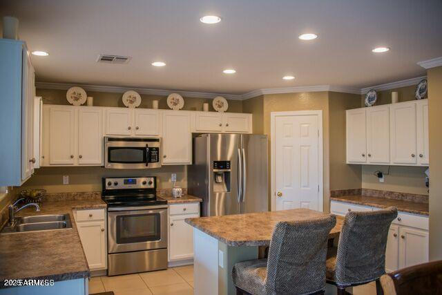 29101 N Yellow Bee Dr, San Tan Valley, AZ 85143 - kitchen with white cabinets, visible vents, a sink, a kitchen bar, and appliances with stainless steel finishes