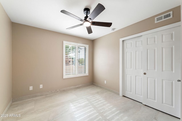 unfurnished bedroom featuring ceiling fan and a closet