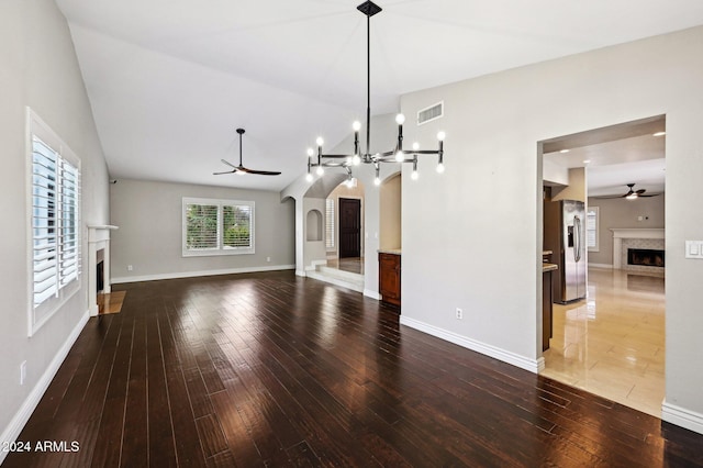 5544 E Paradise Ln, Scottsdale, AZ 85254 - unfurnished living room featuring a fireplace, ceiling fan, hardwood / wood-style floors, arched walkways, and vaulted ceiling