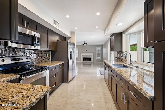 5544 E Paradise Ln, Scottsdale, AZ 85254 - kitchen featuring appliances with stainless steel finishes, decorative backsplash, a ceiling fan, light stone countertops, and recessed lighting