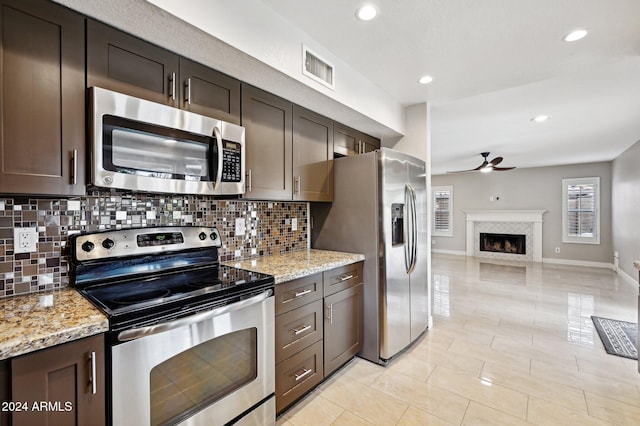 5544 E Paradise Ln, Scottsdale, AZ 85254 - kitchen with stainless steel appliances, ceiling fan, decorative backsplash, open floor plan, and dark brown cabinetry