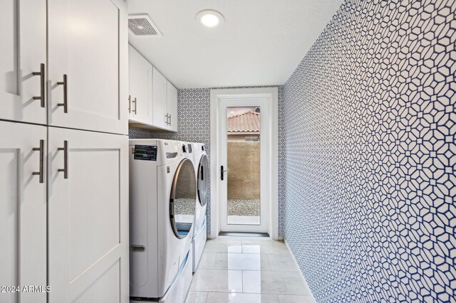 5544 E Paradise Ln, Scottsdale, AZ 85254 - washroom featuring washing machine and clothes dryer, cabinet space, and light tile patterned flooring