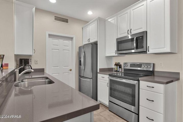 kitchen featuring white cabinets, sink, light tile patterned floors, and stainless steel appliances