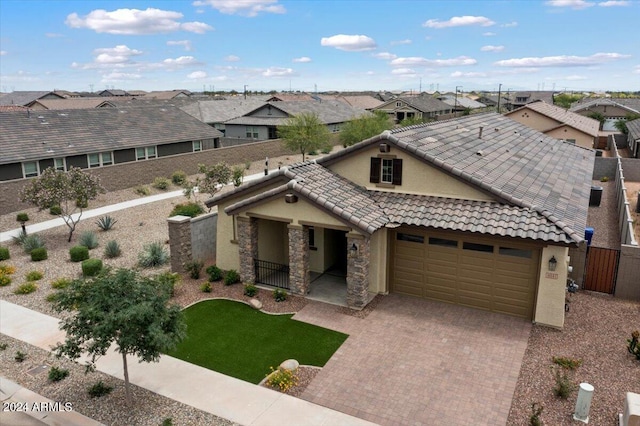 view of front of house with fence, decorative driveway, a garage, a residential view, and stucco siding