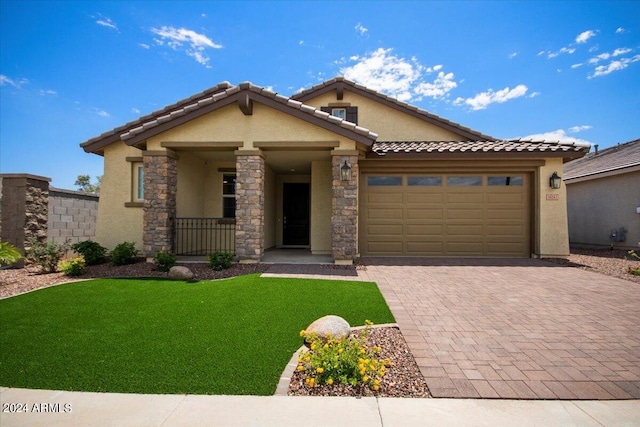 view of front of home with a front lawn, decorative driveway, an attached garage, and stucco siding