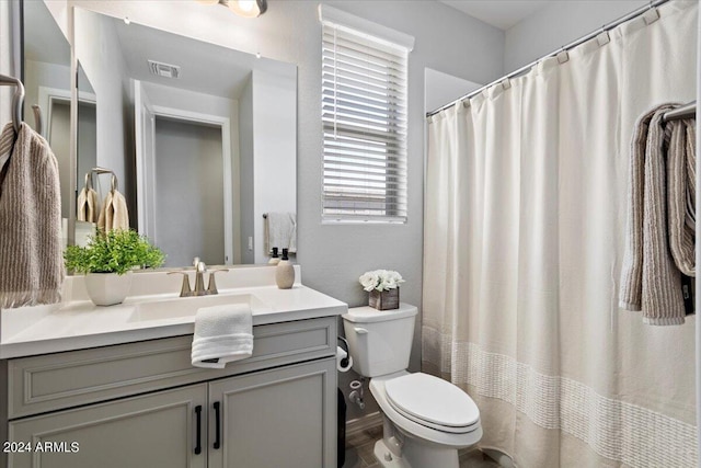 bathroom with visible vents, toilet, vanity, and a shower with shower curtain