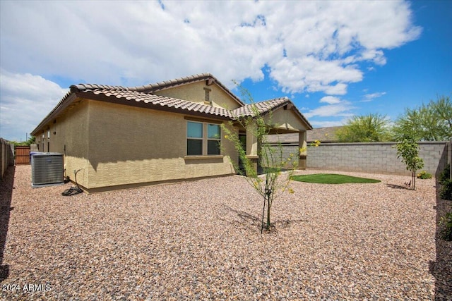 rear view of house featuring stucco siding, a fenced backyard, a tiled roof, a patio, and central AC unit