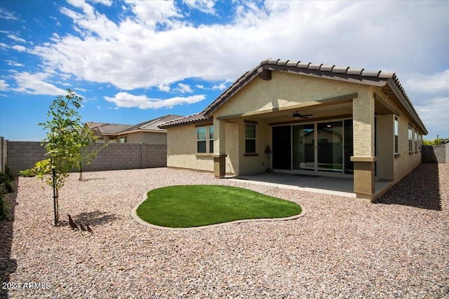 back of property with a fenced backyard, stucco siding, ceiling fan, and a patio