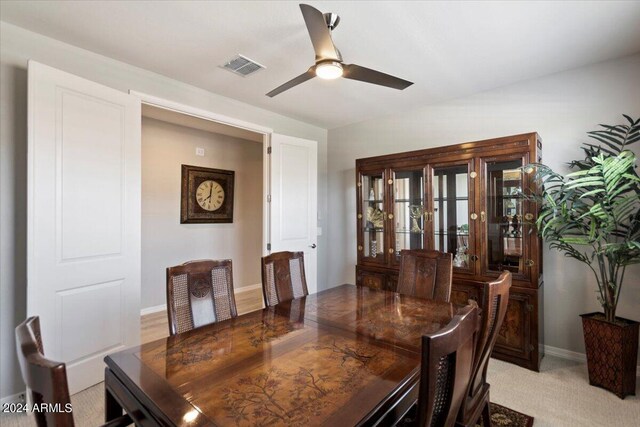dining room featuring a ceiling fan, baseboards, light colored carpet, and visible vents