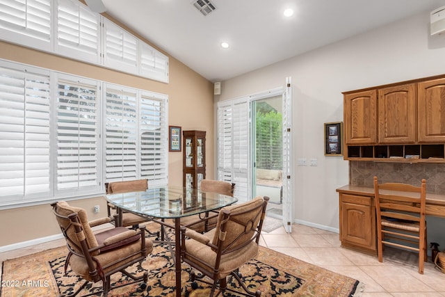 dining space featuring light tile patterned floors and lofted ceiling