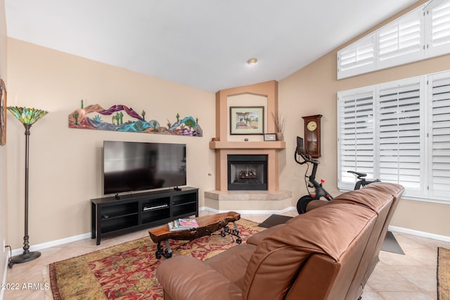 living room with a wealth of natural light, light tile patterned flooring, and vaulted ceiling