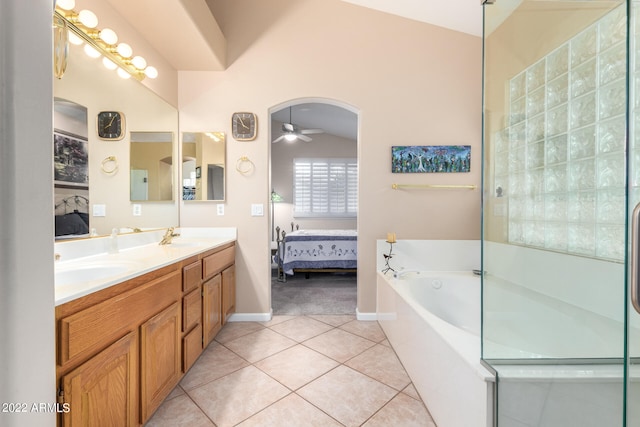 bathroom featuring lofted ceiling, tile patterned floors, tiled bath, vanity, and ceiling fan