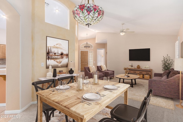 dining room featuring high vaulted ceiling, light colored carpet, and ceiling fan