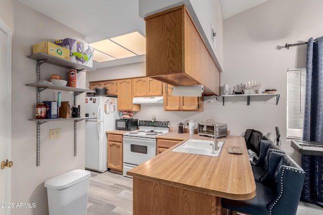 kitchen with sink, light hardwood / wood-style floors, kitchen peninsula, light brown cabinets, and white appliances