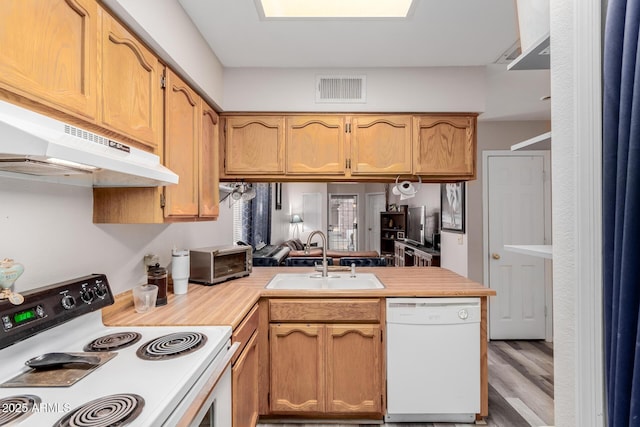 kitchen featuring sink, white dishwasher, range with electric stovetop, kitchen peninsula, and light wood-type flooring