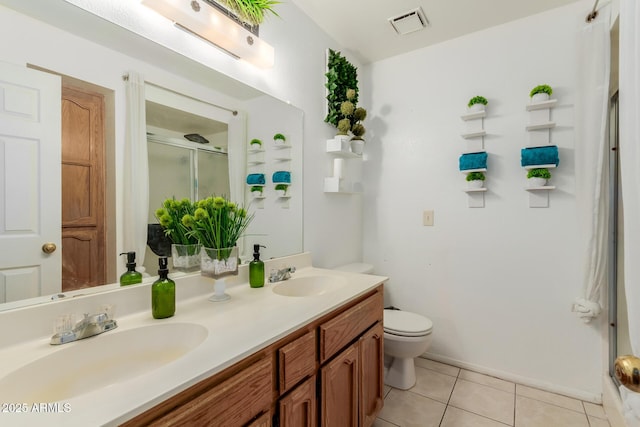 bathroom featuring tile patterned flooring, vanity, a shower with shower door, and toilet