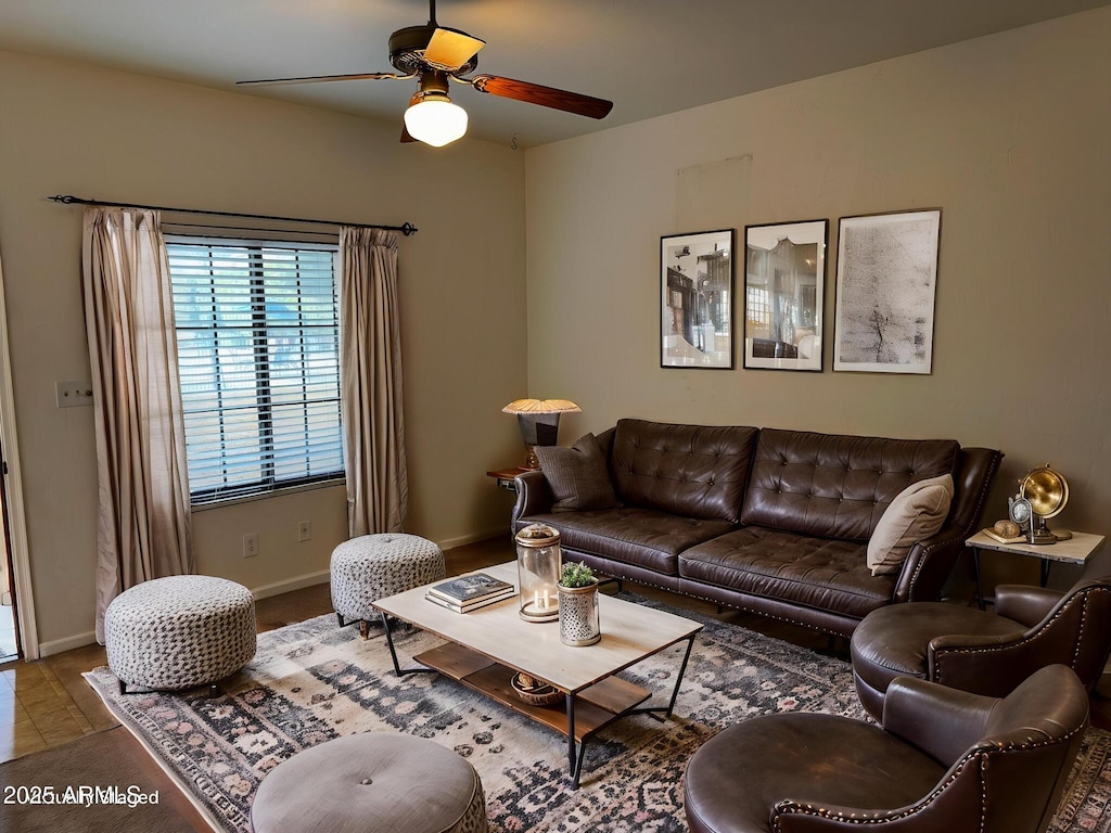 living room with ceiling fan and baseboards
