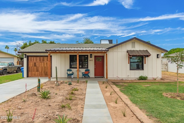 5612 N 9th St, Phoenix, AZ 85014 - single story home with board and batten siding, a porch, an attached garage, concrete driveway, and a front yard