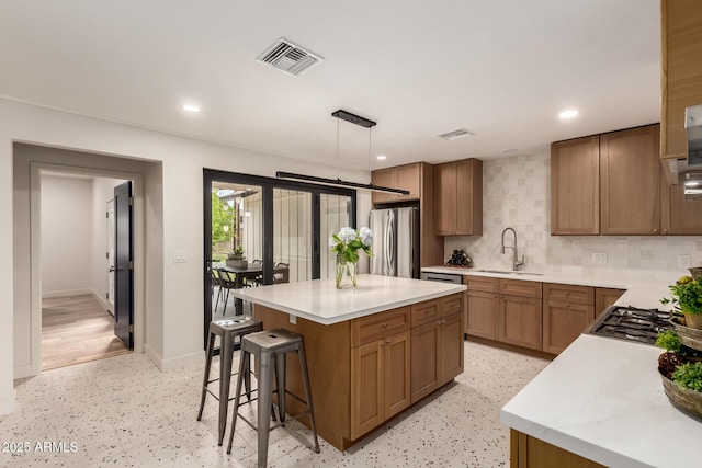 5612 N 9th St, Phoenix, AZ 85014 - kitchen featuring appliances with stainless steel finishes, a sink, a breakfast bar area, light countertops, and tasteful backsplash