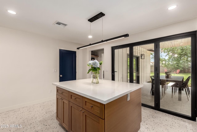 5612 N 9th St, Phoenix, AZ 85014 - kitchen with baseboards, brown cabinetry, recessed lighting, a center island, and light countertops
