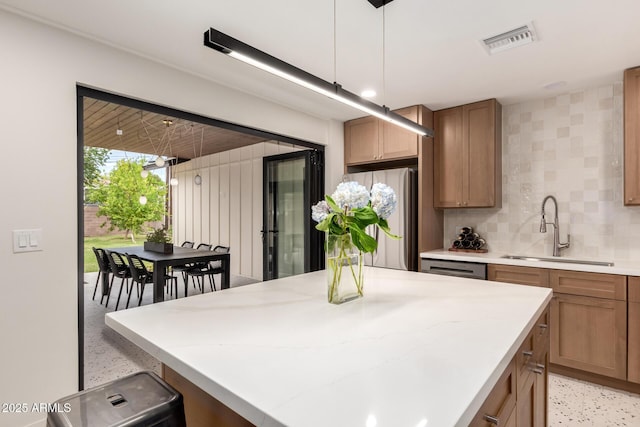 5612 N 9th St, Phoenix, AZ 85014 - kitchen featuring a sink, freestanding refrigerator, backsplash, a center island, and light stone countertops