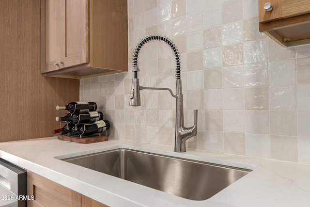 5612 N 9th St, Phoenix, AZ 85014 - kitchen view of a sink, tasteful backsplash, brown cabinetry, and light stone counters
