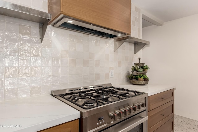 5612 N 9th St, Phoenix, AZ 85014 - kitchen featuring gas range, wall chimney exhaust hood, tasteful backsplash, brown cabinetry, and dark speckled floor