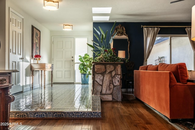 foyer featuring a skylight and dark wood-type flooring