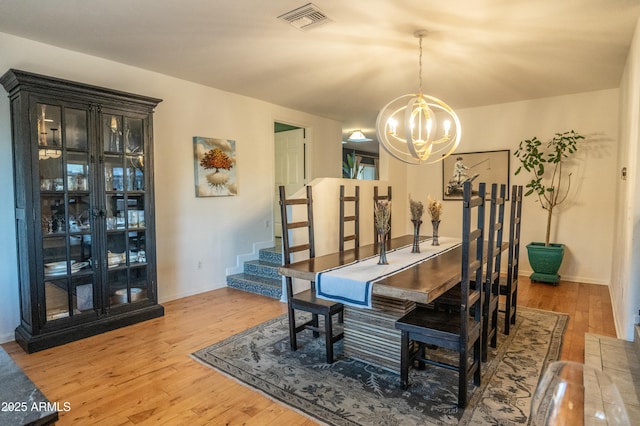 dining area featuring wood-type flooring and an inviting chandelier