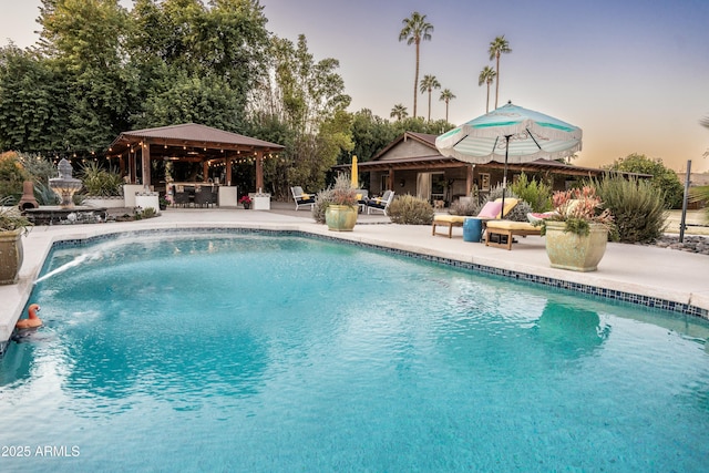 pool at dusk with a patio