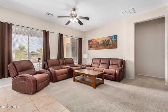 living room with ceiling fan, visible vents, and baseboards