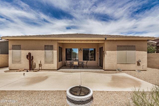 rear view of property featuring a patio, stucco siding, and fence