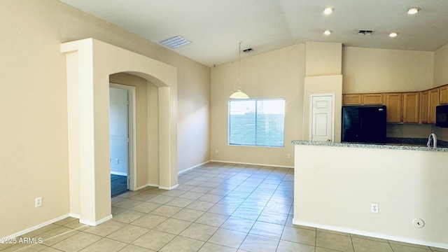 1630 W Pecan Rd, Phoenix, AZ 85041 - kitchen featuring refrigerator, arched walkways, vaulted ceiling, black microwave, and light tile patterned floors