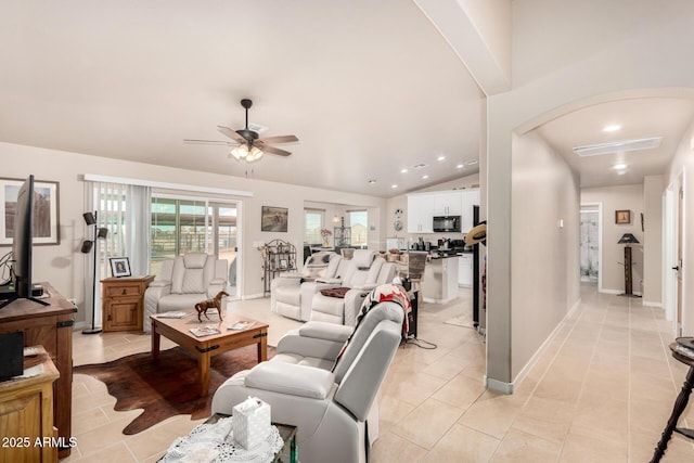 tiled living room featuring ceiling fan and vaulted ceiling