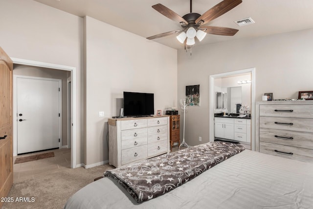 carpeted bedroom featuring ensuite bath and ceiling fan