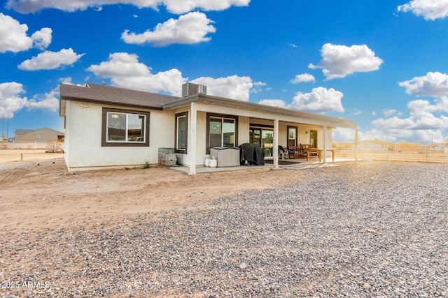 rear view of house with central AC and a patio area