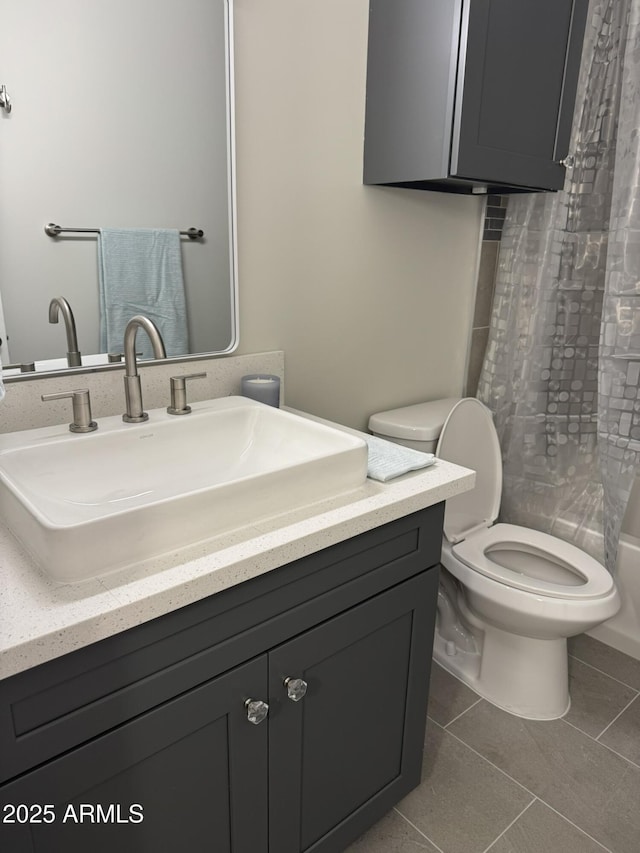 bathroom featuring tile patterned flooring, toilet, and vanity