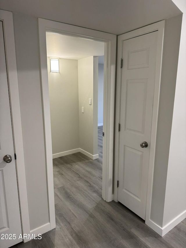 hall with baseboards and wood finished floors