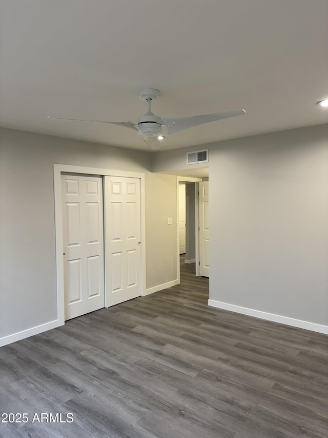 unfurnished bedroom with dark wood finished floors, baseboards, and visible vents