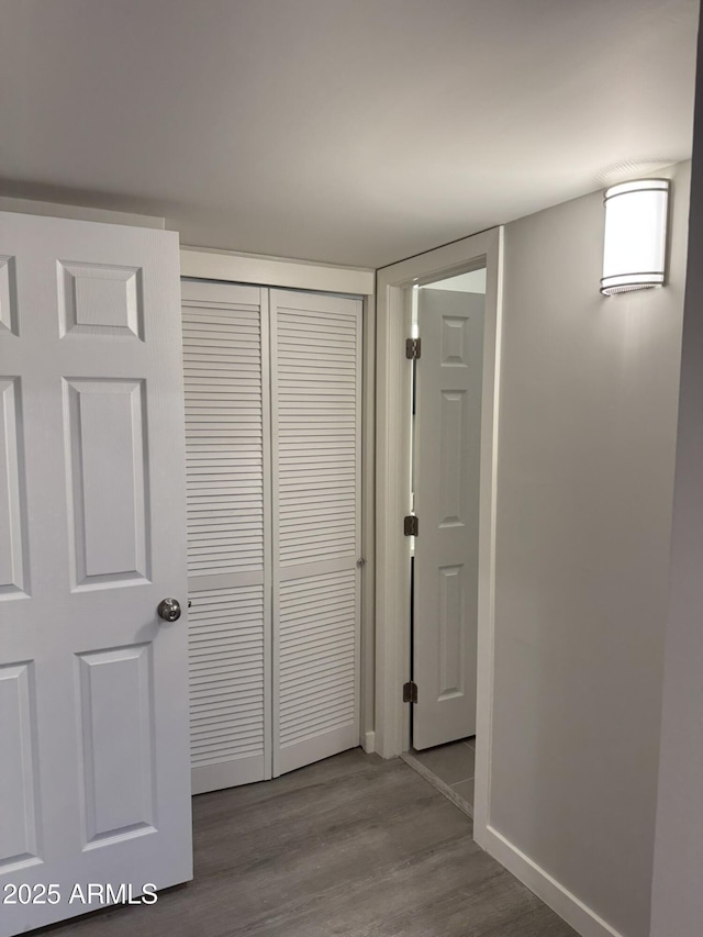 hallway featuring baseboards and wood finished floors