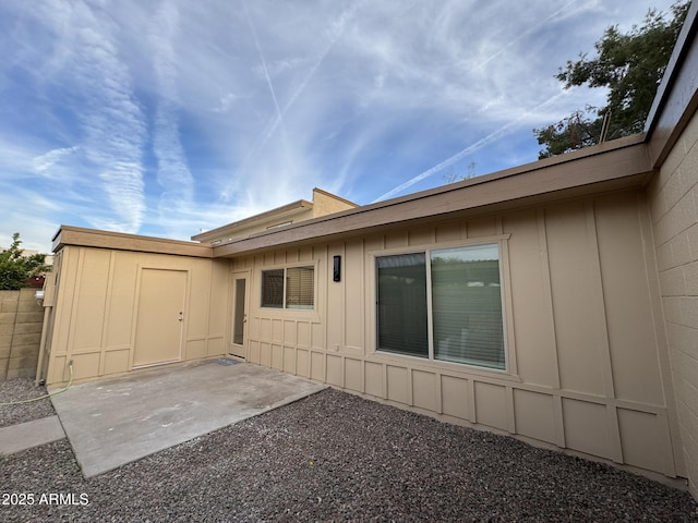 rear view of house with a patio area and board and batten siding