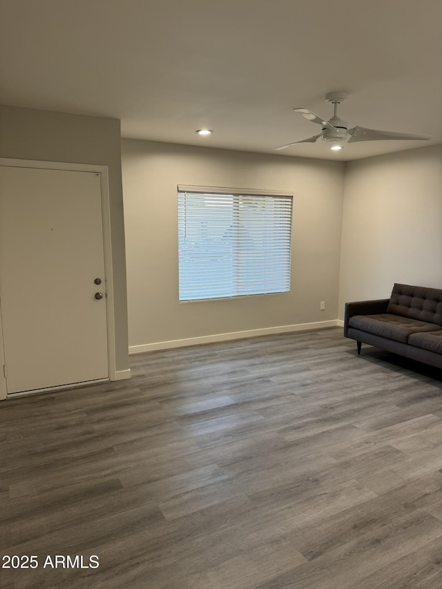 living room featuring dark wood-type flooring, recessed lighting, and baseboards