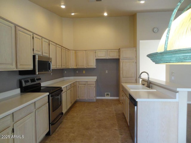 kitchen featuring light countertops, a high ceiling, appliances with stainless steel finishes, and a sink